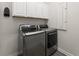 Bright laundry room featuring updated washer and dryer, plus storage cabinets for organizing cleaning supplies at 4599 Storytelling Way, Kissimmee, FL 34746