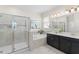 Luxurious main bathroom with a soaking tub, glass-enclosed shower, and dual vanity sinks for a spa-like experience at 4599 Storytelling Way, Kissimmee, FL 34746