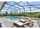Backyard pool and spa inside a screened enclosure surrounded by green nature at 4599 Storytelling Way, Kissimmee, FL 34746