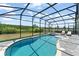 Gorgeous pool with jacuzzi and screened in patio and furniture facing a beautiful field at 4599 Storytelling Way, Kissimmee, FL 34746
