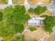 Bird's eye view of home featuring mature trees, gray roof, and a detached garage near a sidewalk-lined street at 499 W Beresford Rd, Deland, FL 32720