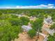 Home surrounded by lush greenery, showcasing a quaint neighborhood with blue sky and scattered clouds above at 499 W Beresford Rd, Deland, FL 32720
