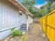 Home's backyard showcasing wooden fence, gravel, and small patio with stairs at 499 W Beresford Rd, Deland, FL 32720