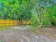 Backyard featuring a new fence, greenery, trees, and a cozy fire pit at 499 W Beresford Rd, Deland, FL 32720