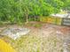 Aerial view of backyard features a new fence, greenery, and a cozy fire pit at 499 W Beresford Rd, Deland, FL 32720