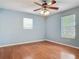 Bright bedroom with a ceiling fan, hardwood floors, and natural light from two windows at 499 W Beresford Rd, Deland, FL 32720