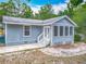 Exterior view showcasing the light blue siding, screened porch, and white-trimmed windows and doors at 499 W Beresford Rd, Deland, FL 32720