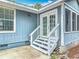 Close-up featuring white-trimmed French doors leading to the screened porch with a concrete patio at 499 W Beresford Rd, Deland, FL 32720