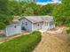 Charming one-story home featuring light blue siding, a screened porch, and a lush, green hedge at 499 W Beresford Rd, Deland, FL 32720