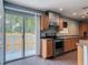Kitchen featuring modern appliances, tile floors, wooden cabinets, and a slider to the exterior at 499 W Beresford Rd, Deland, FL 32720