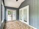 View of a screened porch with tiled floors, gray walls, and double doors leading to the outside at 499 W Beresford Rd, Deland, FL 32720