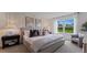 Calm bedroom with plush gray bed, accent pillows, modern artwork, and natural light from the window at 5075 Marshelder, Apopka, FL 32712