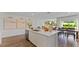 Bright, modern kitchen island with white cabinets, quartz countertops, stainless steel dishwasher, and dining area at 5075 Marshelder, Apopka, FL 32712