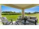 Covered patio with outdoor seating offers a relaxing view of the green backyard at 5075 Marshelder, Apopka, FL 32712