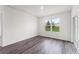 Well-lit bedroom with wood-look flooring, a large window, and sliding glass door to the backyard at 5210 Marshelder, Apopka, FL 32712