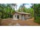 Exterior view of a cozy home surrounded by lush trees, featuring a white door and a sliding glass door at 530 Webster St, Lake Mary, FL 32746