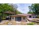 Rear view of a home with an outdoor patio, covered parking and surrounded by mature landscaping at 530 Webster St, Lake Mary, FL 32746