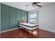 Bedroom with a green accent wall, wood floors, a ceiling fan and a window at 611 Casa Park A Ct, Winter Springs, FL 32708