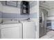Laundry room area with appliances, striped walls and access to the kitchen at 611 Casa Park A Ct, Winter Springs, FL 32708