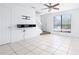 Bright living room features tile flooring, a ceiling fan, and a front door entrance at 611 Casa Park A Ct, Winter Springs, FL 32708