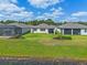 Backyard featuring lush green lawn, mature shrubbery, and screened in back porches at 6121 Blue Pond Way, St Cloud, FL 34771