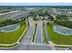 Aerial view of the community entrance featuring mature landscaping and a water feature at 6121 Blue Pond Way, St Cloud, FL 34771