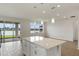 Open-concept living space with a spacious kitchen island overlooking the backyard lake at 6121 Blue Pond Way, St Cloud, FL 34771
