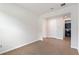 Open space shows wood-style tile floors and access to a kitchen with dark colored cabinets and stainless appliances at 6121 Blue Pond Way, St Cloud, FL 34771