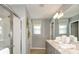 Bright bathroom with double vanity, a glass-enclosed shower, and modern light fixtures at 7315 Capstone Dr, Groveland, FL 34736