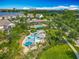 Aerial view of community splash pad, pool, clubhouse, and surrounding homes and landscaping at 7398 Alpine Butterfly Ln, Orlando, FL 32819