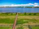 A well-kept backyard with a wooden pier extending into a tranquil lake with a bright blue sky at 7398 Alpine Butterfly Ln, Orlando, FL 32819
