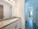 Bathroom with granite vanity, undermount sink, tile flooring, and shower in background at 7398 Alpine Butterfly Ln, Orlando, FL 32819