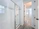 Modern bathroom featuring a glass enclosed shower with decorative tile accents and neutral flooring at 7398 Alpine Butterfly Ln, Orlando, FL 32819