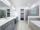 Bathroom features double sinks, a glass shower, a soaking tub, and a walk-in closet at 7398 Alpine Butterfly Ln, Orlando, FL 32819