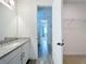 Bathroom with granite countertops, wood look floors, and access to the bedroom and walk-in closet at 7398 Alpine Butterfly Ln, Orlando, FL 32819