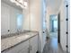 Bathroom featuring a granite countertop vanity, with a door leading to a bedroom at 7398 Alpine Butterfly Ln, Orlando, FL 32819