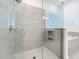 Contemporary bathroom featuring a glass enclosed shower, tiled walls, and a soaking tub at 7398 Alpine Butterfly Ln, Orlando, FL 32819