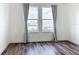 Bright bedroom featuring hardwood floors and a scenic waterfront view from the large windows at 7398 Alpine Butterfly Ln, Orlando, FL 32819