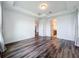 Bright bedroom showcasing wood flooring and neutral walls, with doorways leading to other rooms at 7398 Alpine Butterfly Ln, Orlando, FL 32819