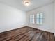 Clean bedroom featuring hardwood floors, neutral walls, and two windows with white shutters at 7398 Alpine Butterfly Ln, Orlando, FL 32819