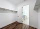 Walk-in closet with wood-look floors and access to a modern bathroom with glass-enclosed shower at 7398 Alpine Butterfly Ln, Orlando, FL 32819