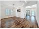 Elegant dining room showcasing hardwood floors, a modern chandelier, and large windows with shutters at 7398 Alpine Butterfly Ln, Orlando, FL 32819