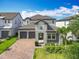 Gorgeous two-story home with a 2-car garage, brick driveway, stone facade and well-manicured landscaping at 7398 Alpine Butterfly Ln, Orlando, FL 32819