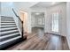 Bright foyer featuring hardwood floors, a staircase with black iron railings, and ample natural light at 7398 Alpine Butterfly Ln, Orlando, FL 32819