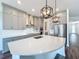 Bright kitchen featuring gray cabinets, stainless steel appliances, range hood and a large island with a white countertop at 7398 Alpine Butterfly Ln, Orlando, FL 32819
