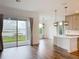 Open-concept living room with wood floors, lake views from large sliding doors, and a kitchen island nearby at 7398 Alpine Butterfly Ln, Orlando, FL 32819