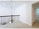 Loft area with iron railing and a modern hanging light fixture, carpet, and entry ways at 7398 Alpine Butterfly Ln, Orlando, FL 32819
