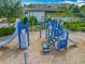 Community playground with blue climbing structure, slides, and wood chip ground cover at 7398 Alpine Butterfly Ln, Orlando, FL 32819