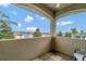 A covered balcony provides lovely views of the surrounding community and blue skies at 7564 Marker Ave, Kissimmee, FL 34747