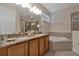 Bright bathroom featuring a bathtub, dual sinks, and granite countertop at 7564 Marker Ave, Kissimmee, FL 34747